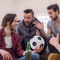 Männer mit Fußball und Bier die diskutieren