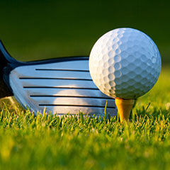 Ein Golfball und ein Golfschläger in Nahaufnahme auf Rasen